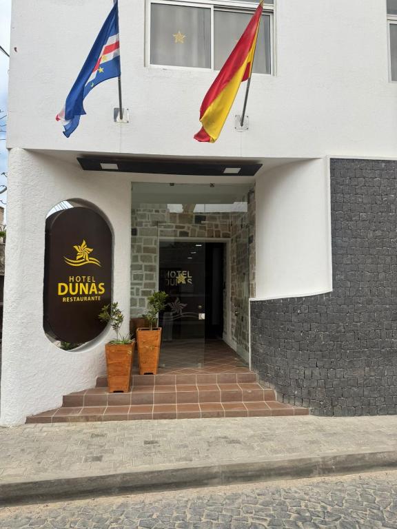 two flags are flying outside of a building at Hotel Dunas Boavista in Sal Rei