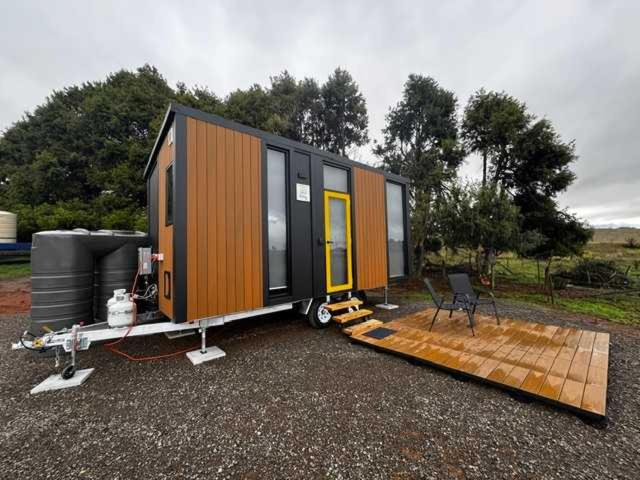 a tiny house is sitting on a trailer at The Dairy and Pines Tiny house by Tiny Away in Shadforth