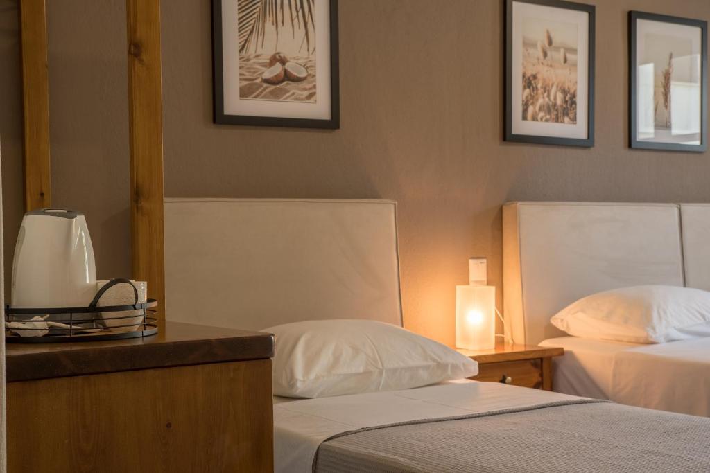 a hotel room with two beds and a table with a lamp at Hotel Cleopatra in Chorefto