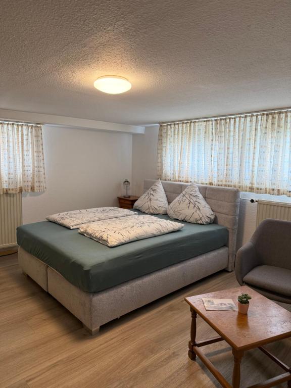 a bedroom with a bed and a couch and a table at Van Kim 2 - Souterrain Monteurwohnung in Emden