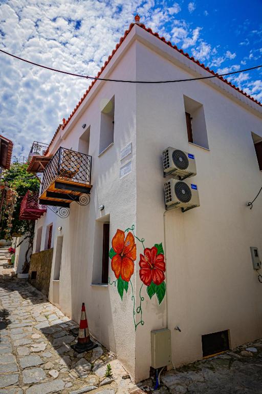a building with flowers painted on the side of it at Calliοpe's home in Skiathos