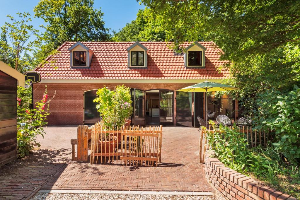 a brick house with a fence and an umbrella at Bakkumer Strand in Castricum