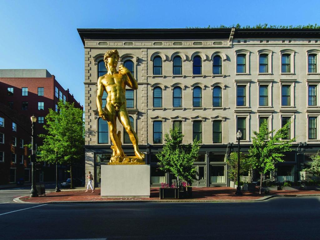 a gold statue in front of a building at 21c Museum Hotel Louisville in Louisville
