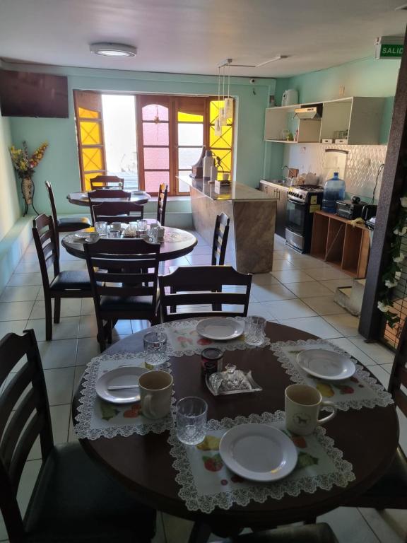 a dining room and kitchen with a table and chairs at Hotel Simon in Antofagasta