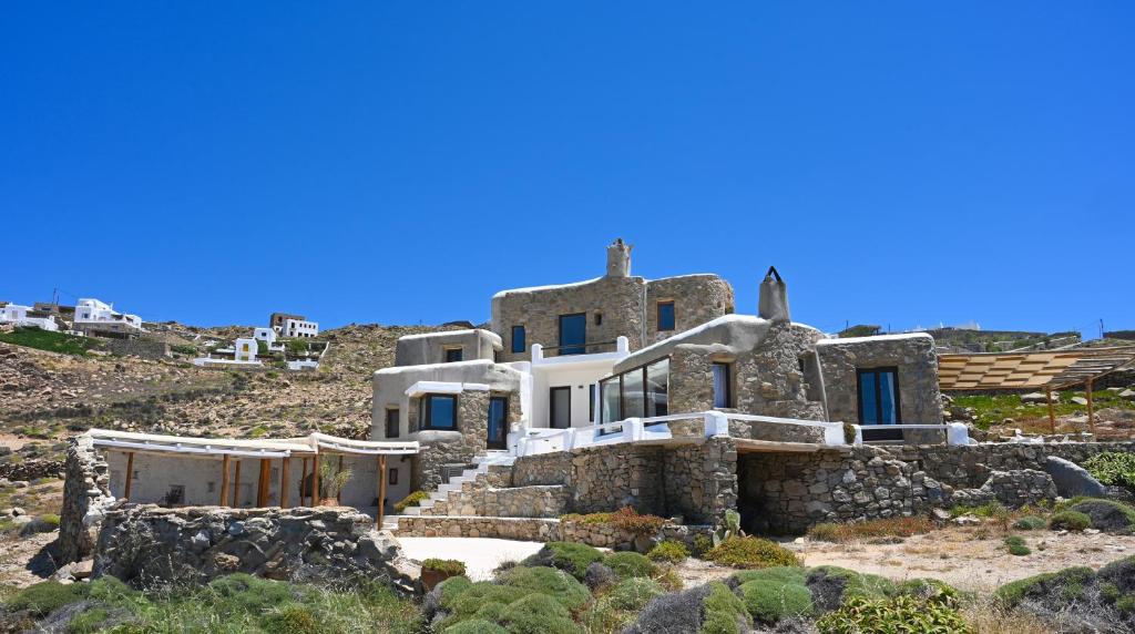 a house on the side of a hill at ⋆ 5BR Oceanside View Near Lighthouse- Pharos VM ⋆ in Mikonos