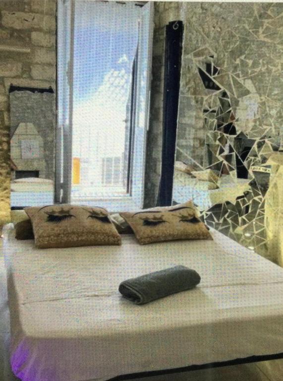 a bed with two pillows in a room with a window at Appartamento Centrale Apeneste in Vieste