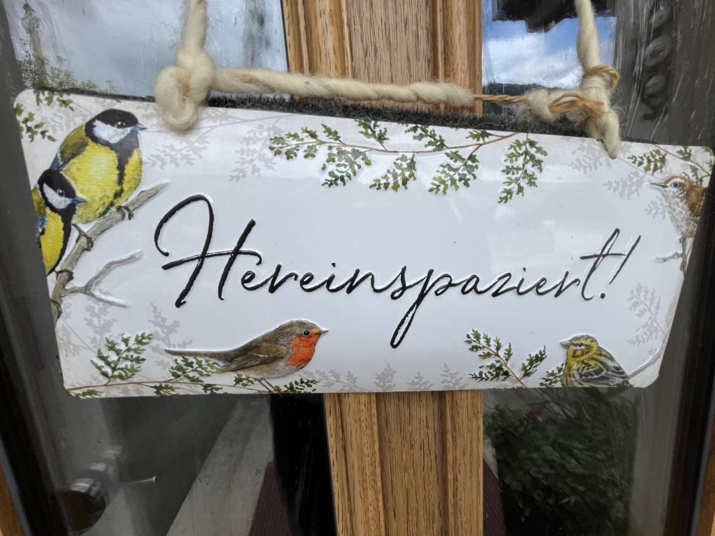 a sign in a window with birds on it at Ferienwohnung 1 Am Krepbach in Grainau