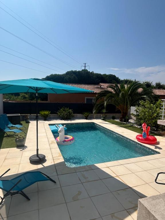 a swimming pool with an umbrella and a swimming pool at Appartement piscine Puget-sur-Argens in Puget-sur-Argens
