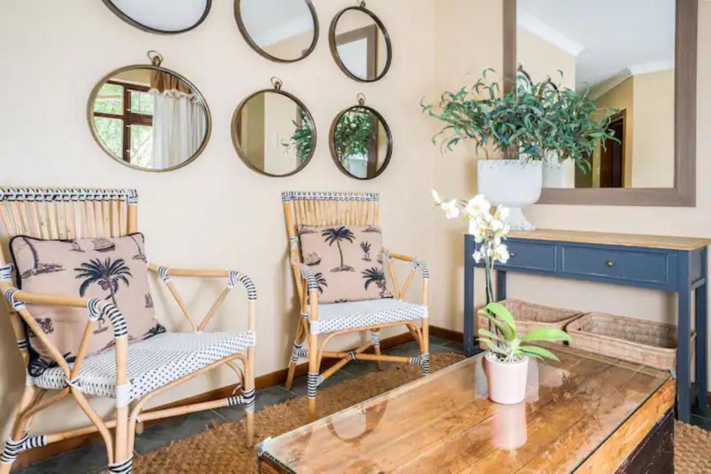 two chairs and a table in a room with mirrors at Avemore Island Apartment Sedgefield in Sedgefield