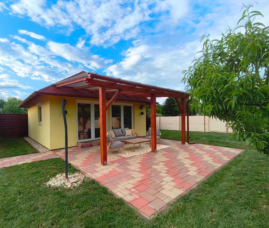 a pavilion with a bench on a brick patio at Marilyn Vendégház in Kehidakustány