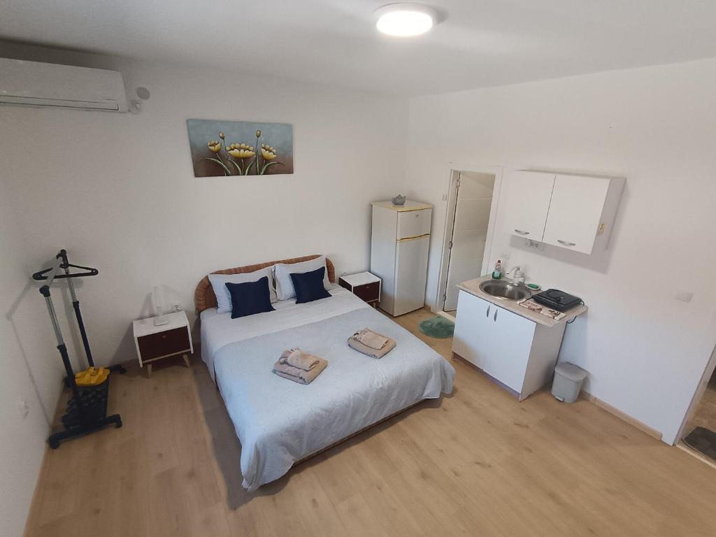 a bedroom with a large white bed with blue pillows at Komforna Soba U Centru #3 in Mladenovac