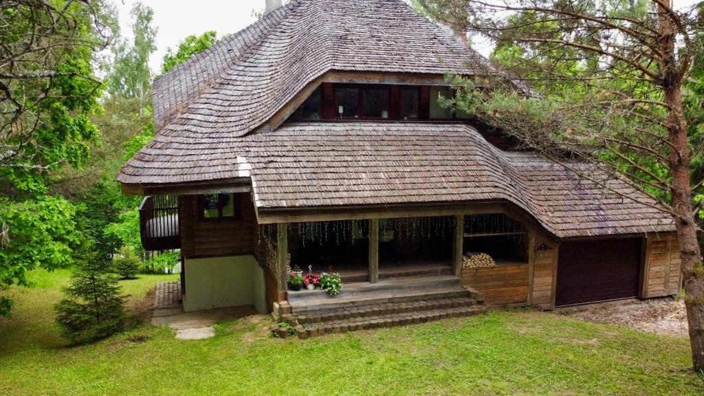 a small house with a shingled roof at Vizbuļi, Amatciems in Amatciems