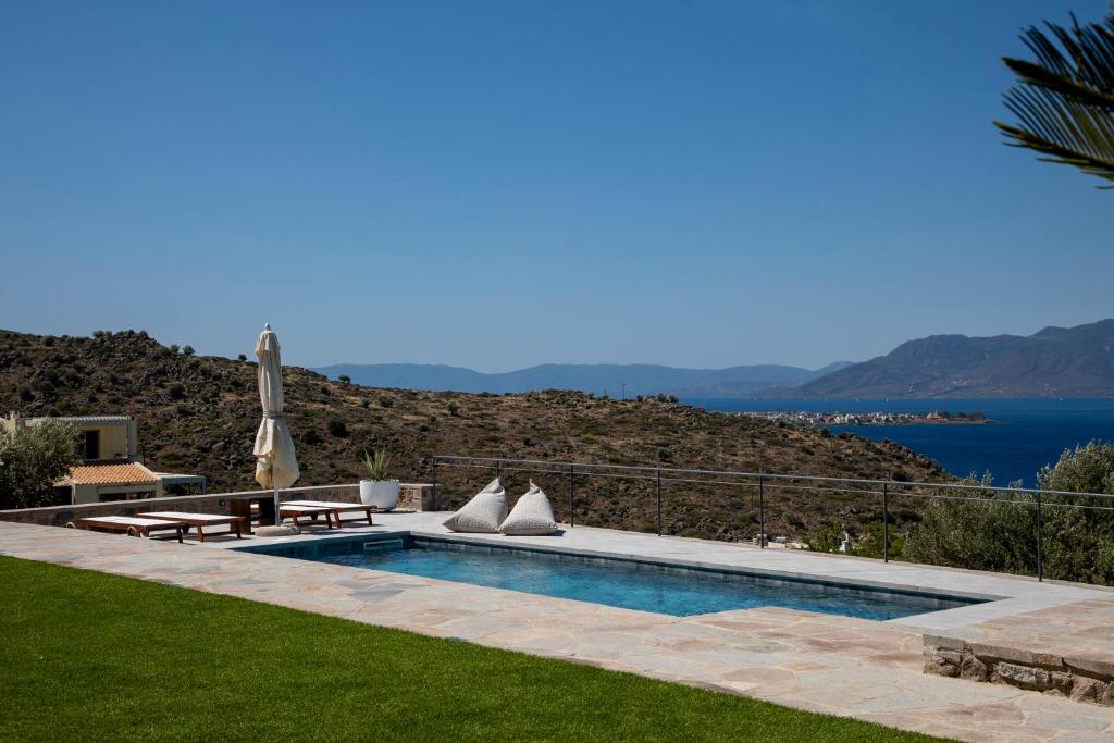a swimming pool with a view of the water at White Stone Villa in Marathonas