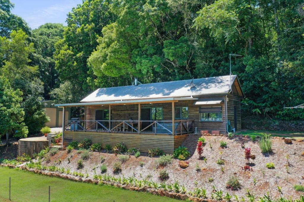 a log cabin with a garden in front of it at Bellthorpe Retreat in Bellthorpe