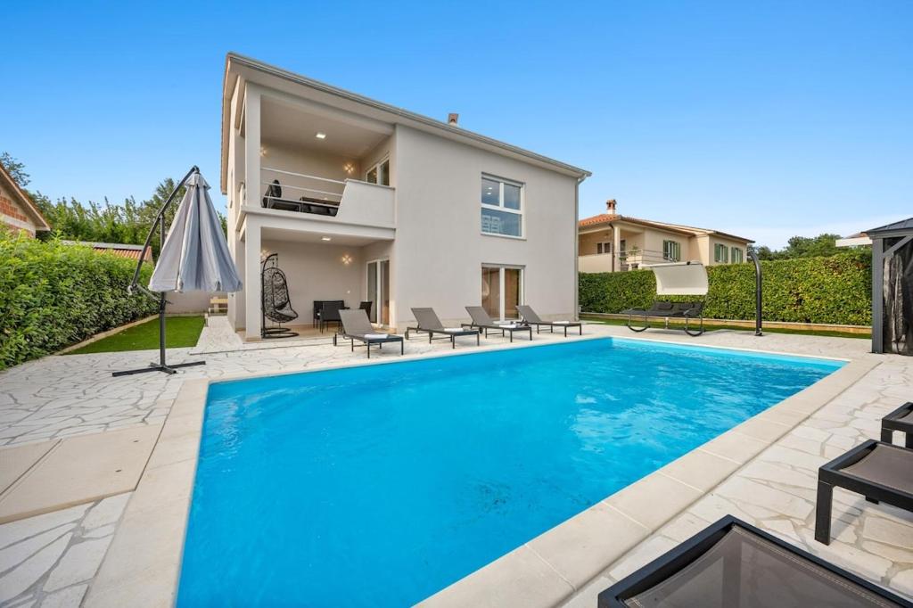 a swimming pool in the backyard of a house at Villa LanaB - Private Pool - by Istrabook in VeliGolji