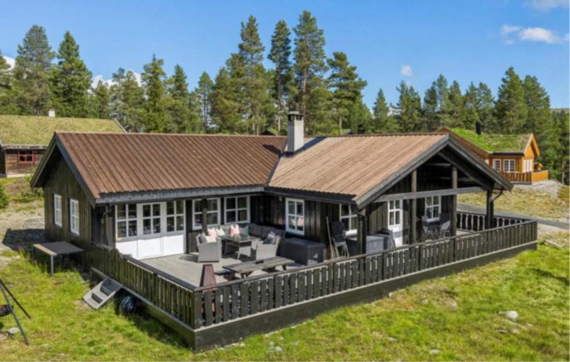 a large house with a large deck in the yard at Jegertråkket 13 in Sør-Fron