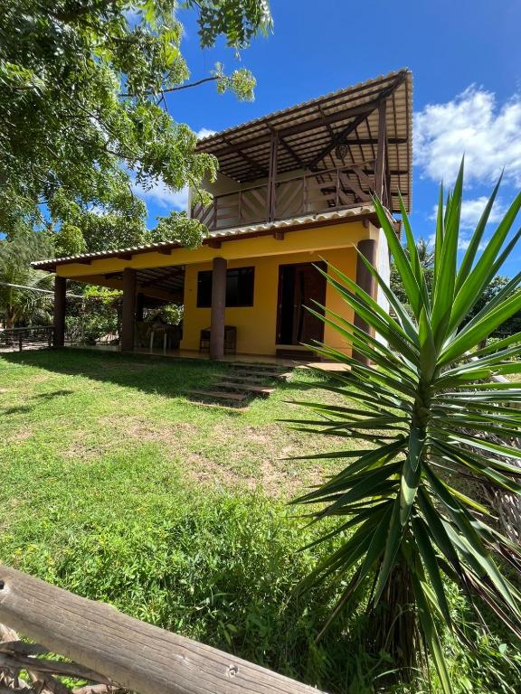 ein gelbes Haus mit einer Palme davor in der Unterkunft Wind Life in Itarema