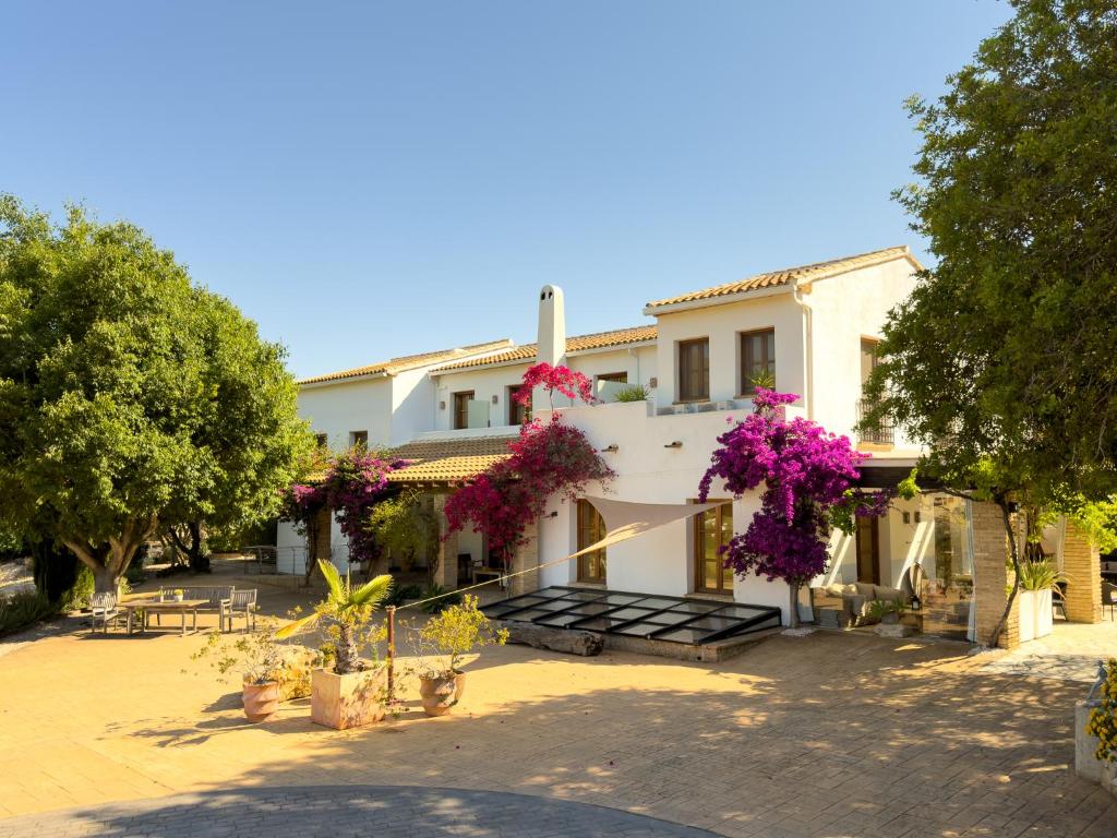a building with flowers on the side of it at Hotel Castell de la Solana in Alcalalí