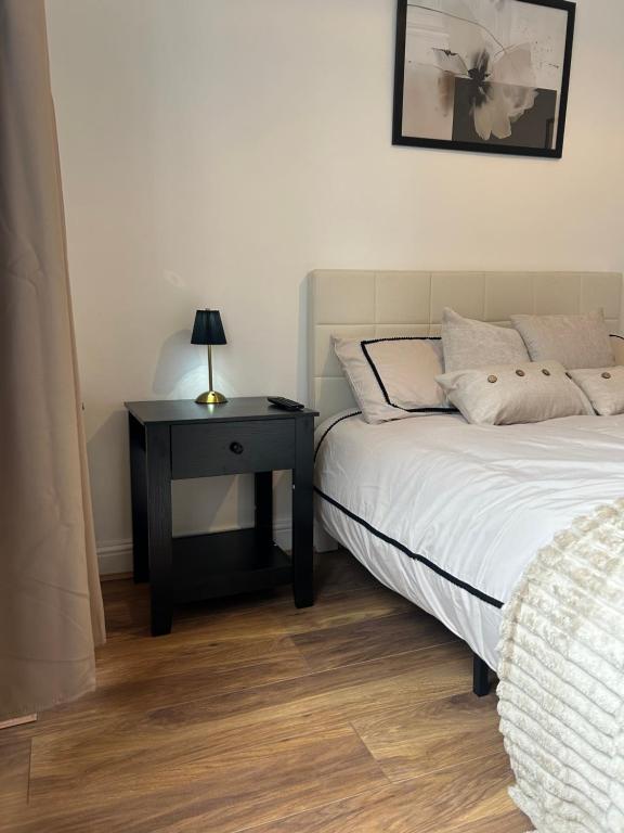 a bedroom with a bed and a table with a lamp at Newly Refurbished House in Norwood