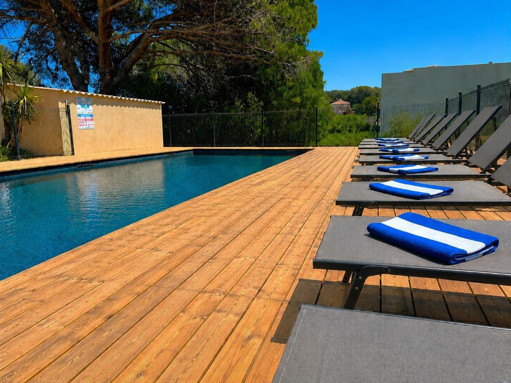 a row of lounge chairs next to a swimming pool at Bungalows Filippi in Porto-Vecchio