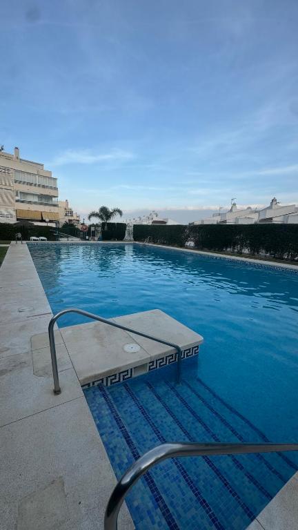 a swimming pool with blue water in a building at Luxury Estudio CH&H in Benalmádena