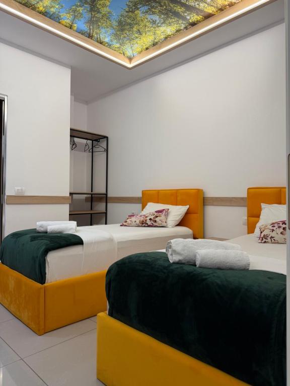 two beds in a room with a skylight at AA Boutique Hotel in Shkodër