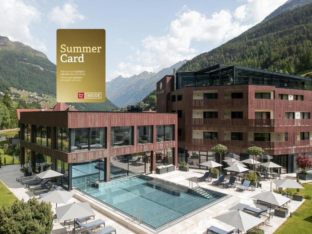 a hotel with a swimming pool in front of a building at AlpenParks THE SECRET Sölden in Sölden
