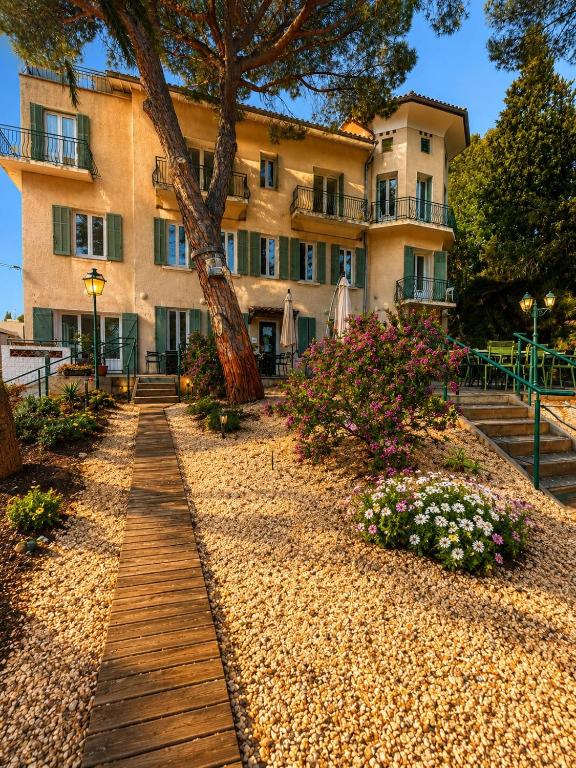 a building with a wooden walkway in front of it at Hotel VTF Clairefont - Bandol in Bandol