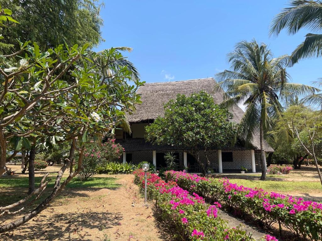 a house with pink flowers in front of it at Malindi Mambrui Villa in Malindi