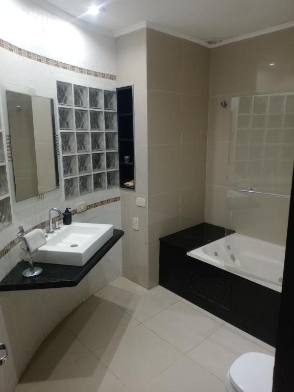 a bathroom with a sink and a tub and a toilet at Casa calle San José in Gualeguaychú