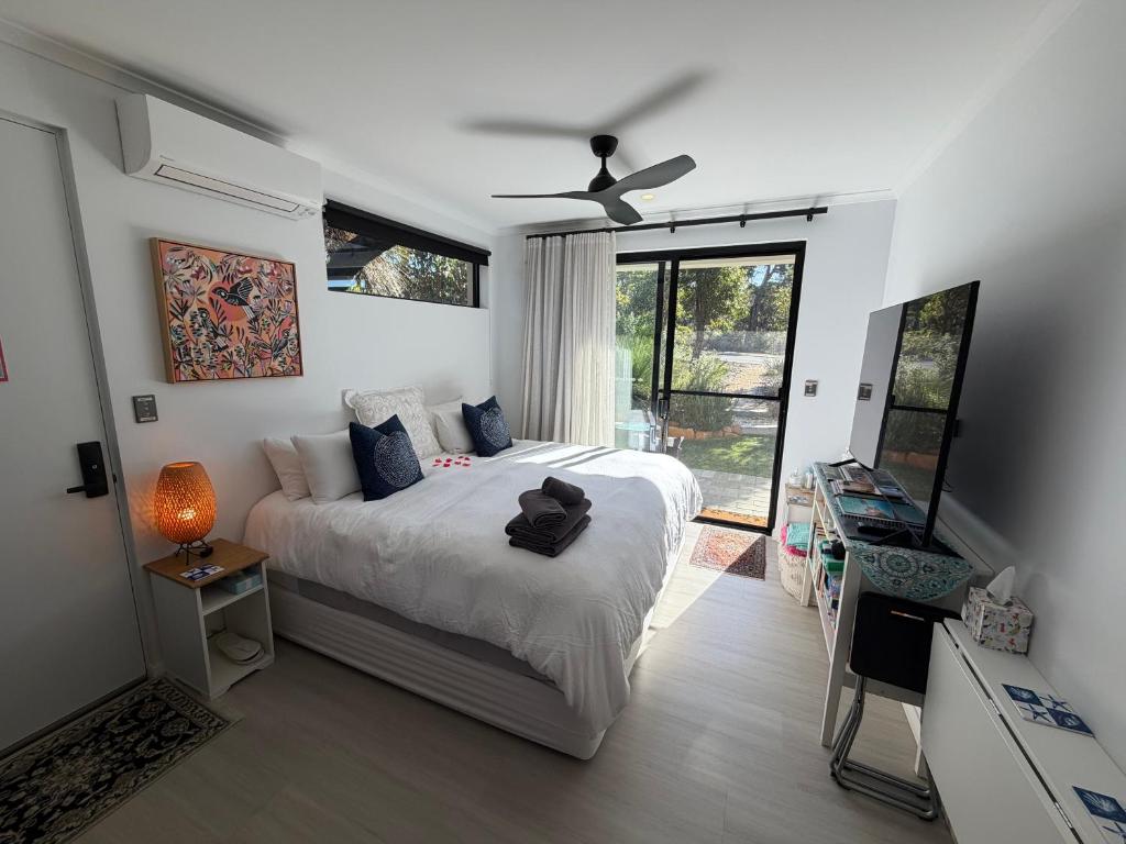 a bedroom with a bed and a ceiling fan at Carnarvon Castle Eagle Bay in Dunsborough