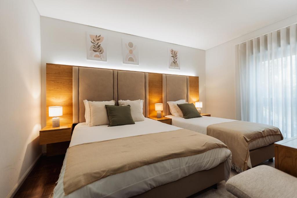 a hotel room with two beds and a window at Vistas da Villa in Cabeceiras de Basto