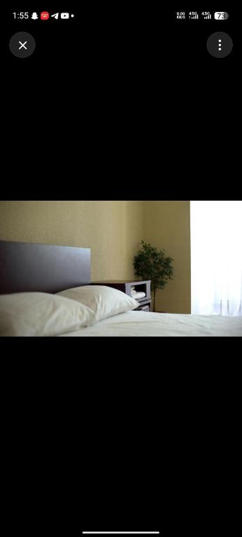 ein Schlafzimmer mit einem weißen Bett und einem Fenster in der Unterkunft Little base hotel in Ale