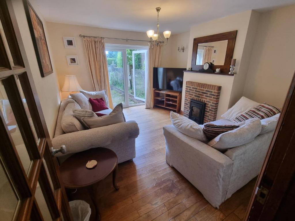 a living room with two couches and a fireplace at Maryland Cottage Nr Gatwick in Godstone