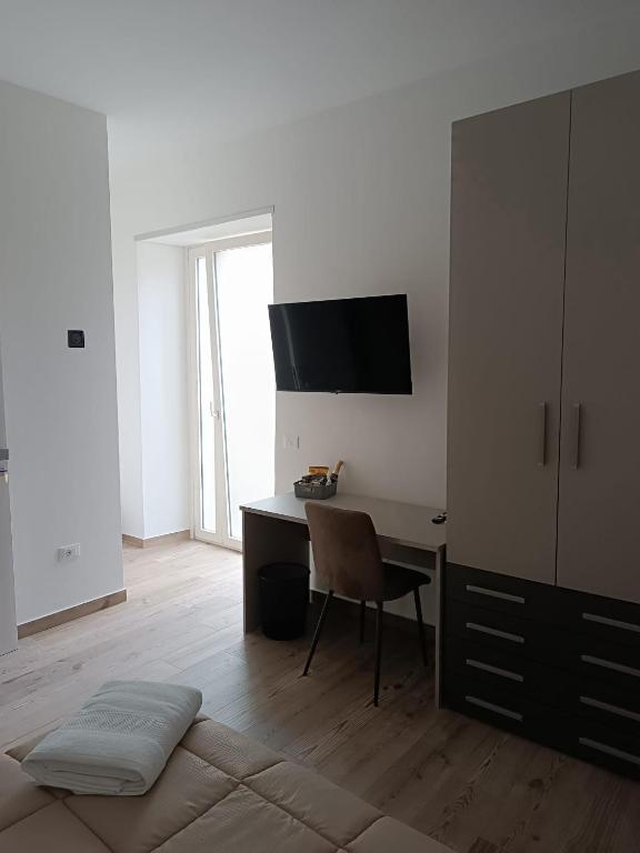 a room with a desk with a chair and a television at Maison MariEtt - Smart & Living Suites - in Troia