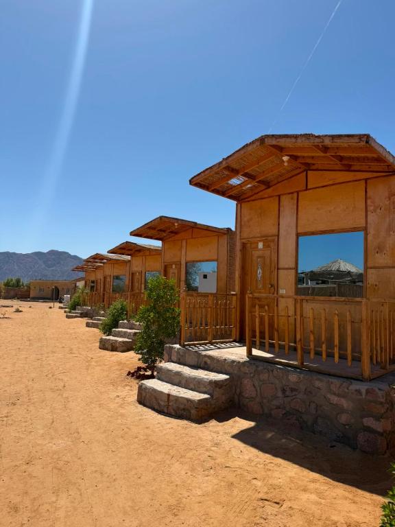 a row of wooden buildings in the desert at Moon Dune Camp in Nuweiba