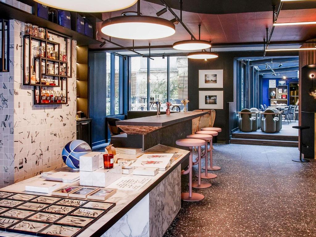 a restaurant with a bar with stools at TRIBE Paris Batignolles in Paris