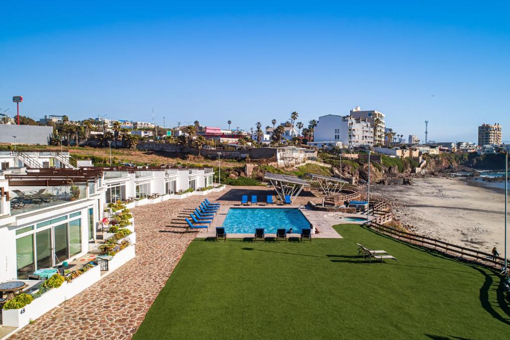 a resort with a swimming pool next to a beach at Dog-Friendly Beach Haven with Heated Pool, Hot Tub, Kitchenette, Patio, AC in Rosarito