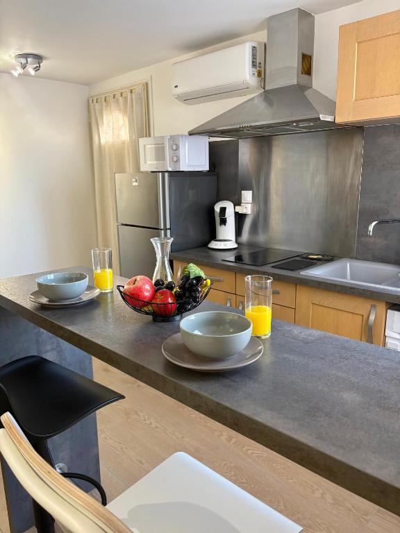 a kitchen with two bowls of fruit on a counter at Studio avec Wi-Fi, à 5mn de la Centrale du Bugey in Loyettes