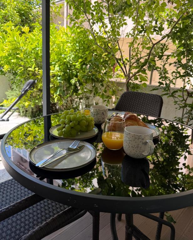 a glass table with food and drinks on a patio at Laganini Apartments in Split