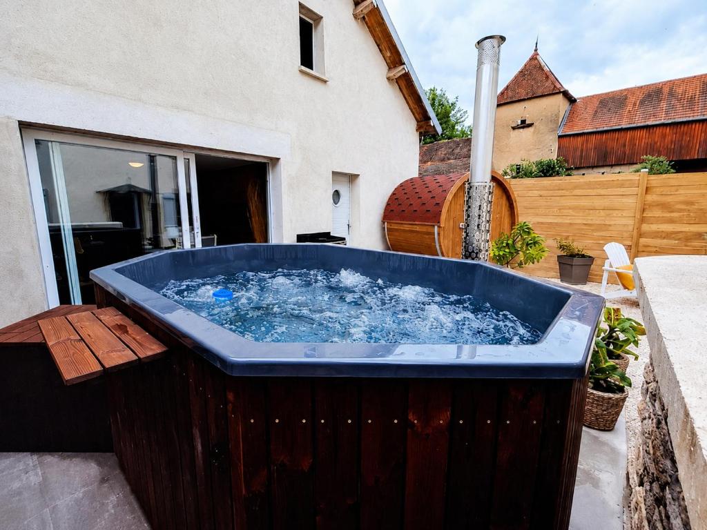 a large blue tub sitting on a patio at L' Ecrin de Suzanne-Maison de 180M2 avec sauna et bain nordique privatifs in Ray-sur-Saône