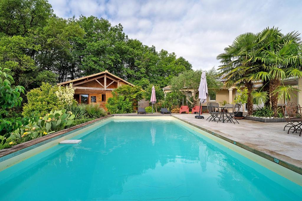 a swimming pool in front of a house at Chalet En Périgord Vert in Sainte-Croix-de-Mareuil