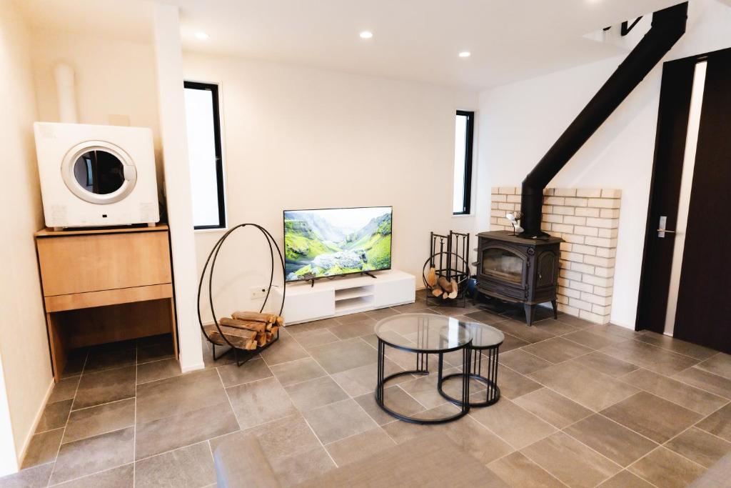 a living room with a television and a stove at SANMI Hayama in Hayama
