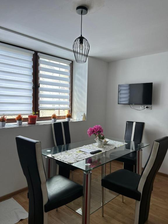 a dining room with a glass table and chairs at Stan na dan Čajniče in Čajniče