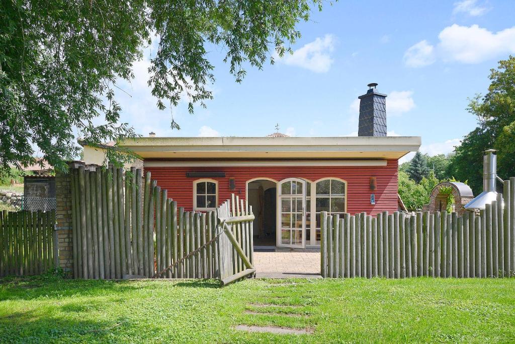 a red house with a fence in front of it at Ferienhaus Reiseoase in Bützow