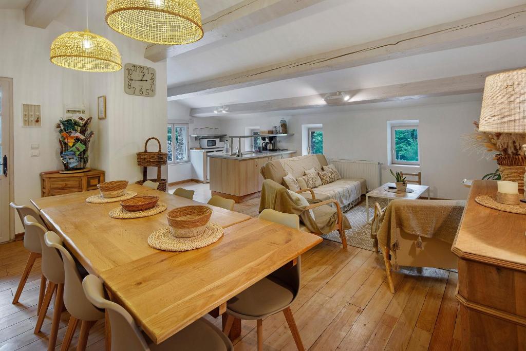 a dining room and living room with a wooden table at Le Mas de la Rode in Saumane