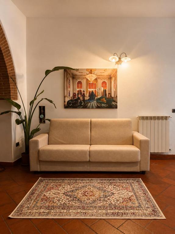 a couch in a living room with a painting on the wall at Residenza Vittoria nell'Antico Borgo in Piombino