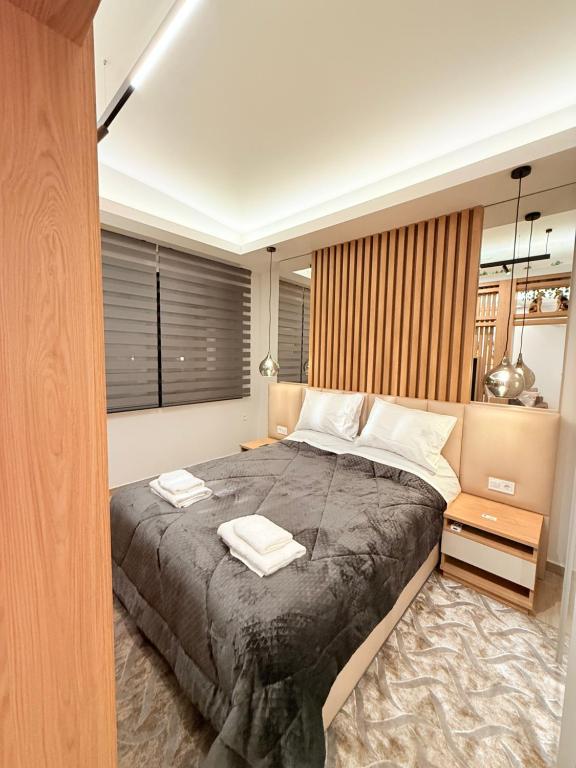 a bedroom with a large bed with two towels on it at Velvet Aura Suites Edessa in Edessa