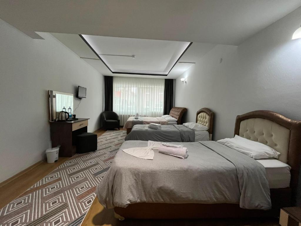 a hotel room with two beds and a couch at Nora Palace Hotel in Develi