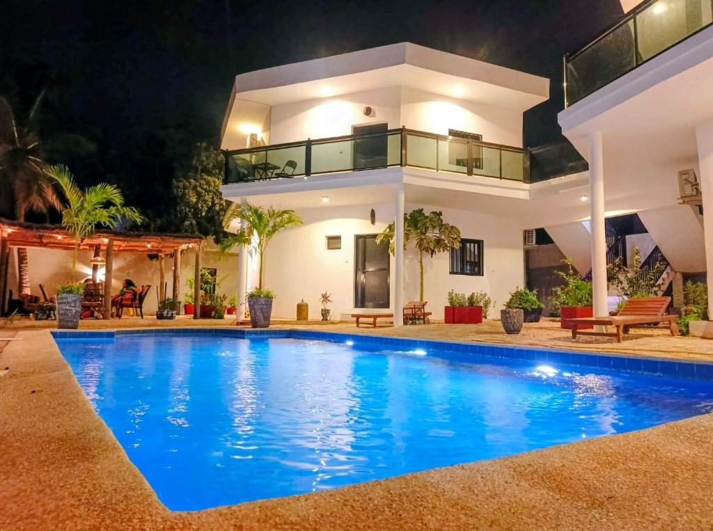 a villa with a swimming pool at night at Izuba chambres avec vue sur piscine in Ngaparou